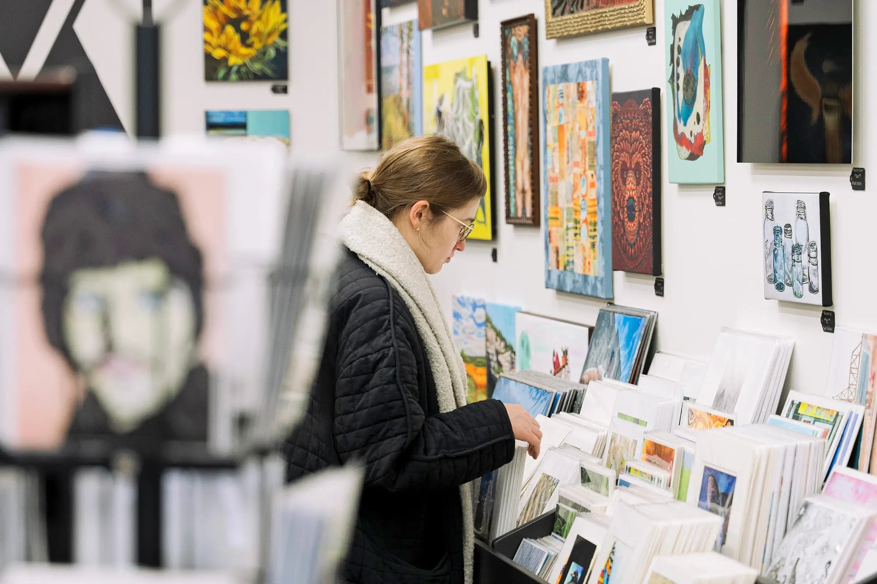 Customer shopping for art prints at Madison Art Market in Madison, WI.
