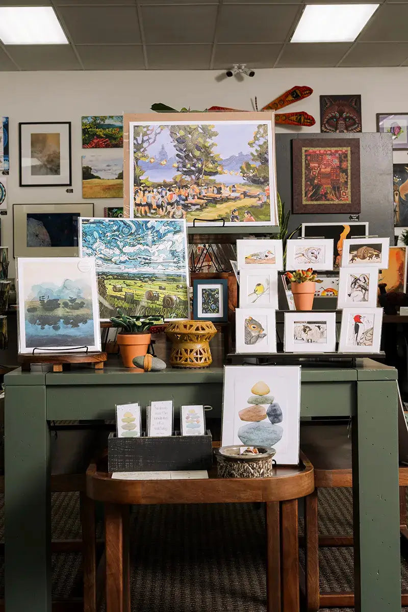 Small original artworks and prints arranged on a table at Madison Art Market in Madison, Wisconsin